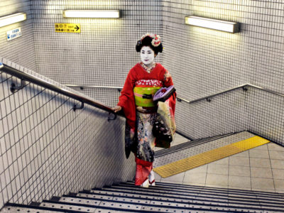 Geisha-walking-up-the-stairs-of-an-office-building,-Kyoto,-Japan,-2007,-by-McCurry