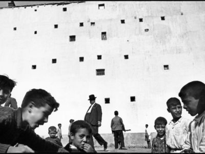 Cartier-Bresson,-A-group-of-people-in-front-of-a-wall-filled-with-small-windows,-Madrid,-Spain-1933